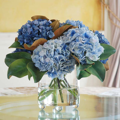 Artificial blue hydrangeas in glass vase